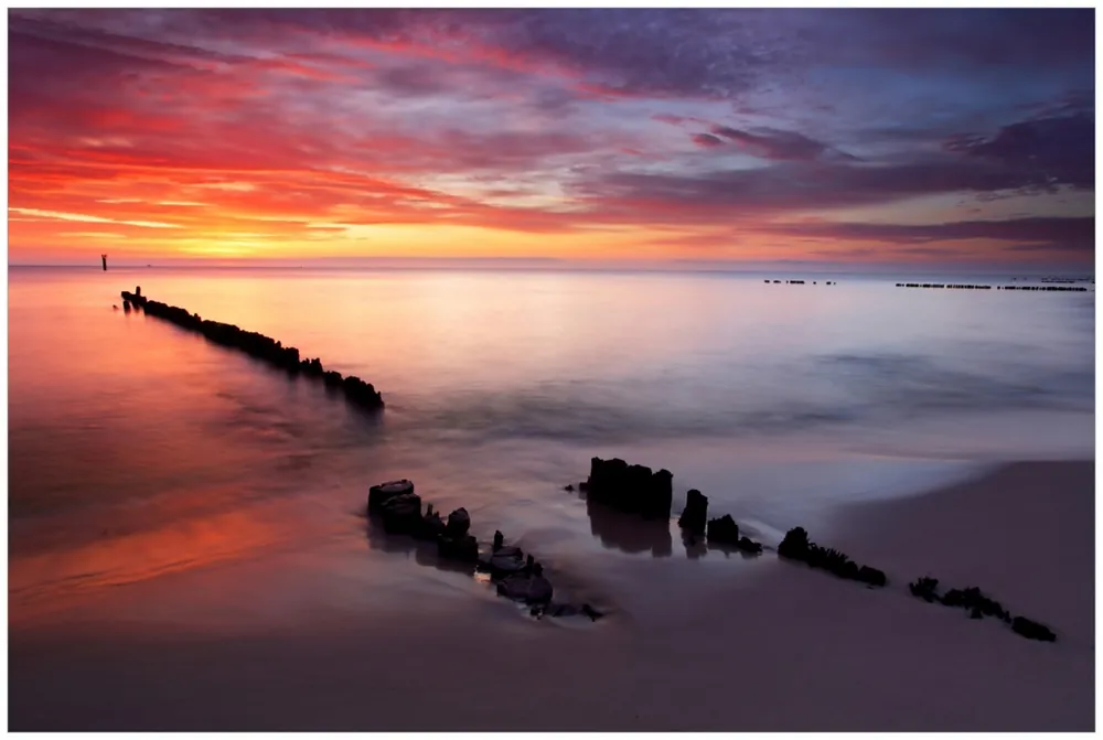 Glasbild Sandstrand im Sonnenuntergang - Roter Himmel 70 x 100 cm Top-Seller