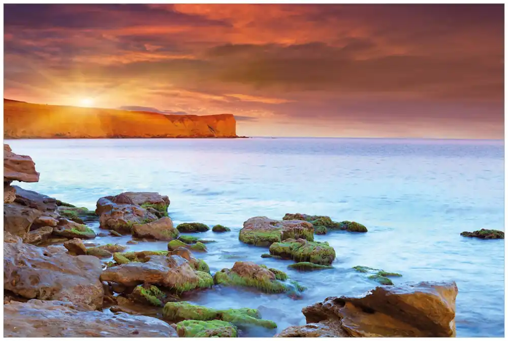 Günstig Glasbild Sonnenaufgang am Meer mit Landzunge und Felsen im Wasser 50 x 125 cm